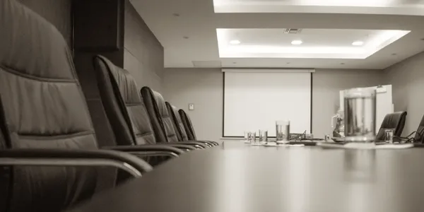 Moderner Konferenzraum mit großem Besprechungstisch und Präsentationsfläche